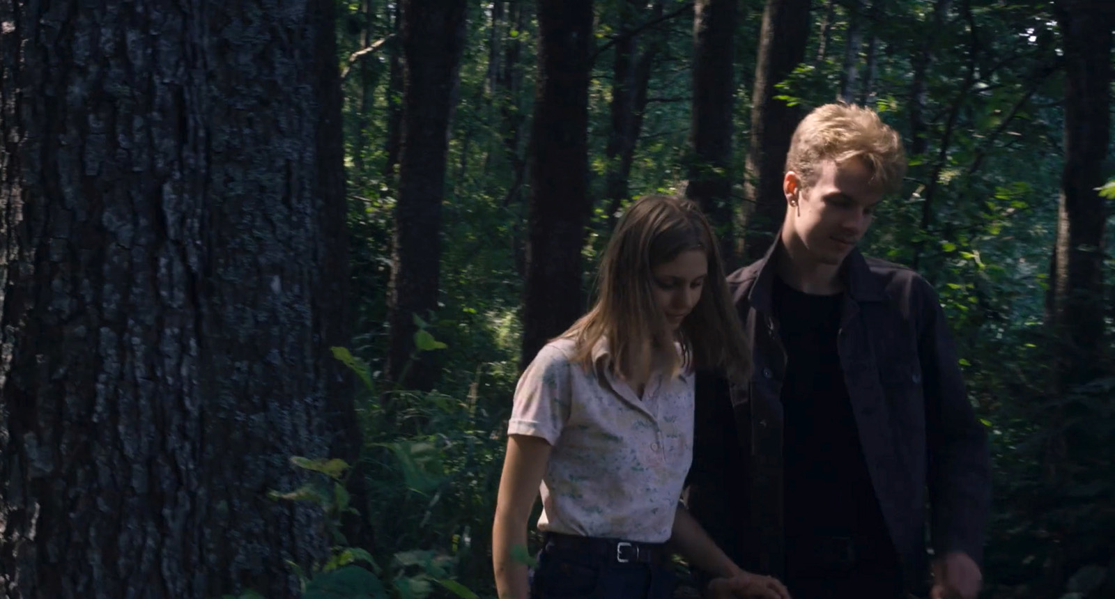 Un jeune couple (une femme et un homme) se promène dans la forêt